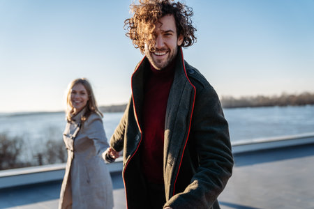 A warm and loving couple enjoys a joyful moment surrounded by vibrant autumn foliageの写真素材