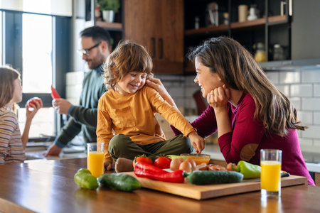 A happy family is cooking together in a bright kitchen, showing joy, teamwork, and love at homeの写真素材