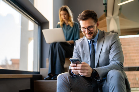 Busy smiling executive business team using digital devices in office. Diverse professional peopleの写真素材