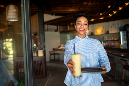 Young black woman working in a stylish cafe, diversity, pride in a modern professional environmentの写真素材