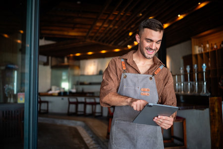 Passionate barista and business owner bringing warmth and quality service to his stylish coffee shopの写真素材
