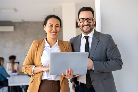 Happy multiethnic businesspeople laughing while collaborating on a new project in an office.の写真素材