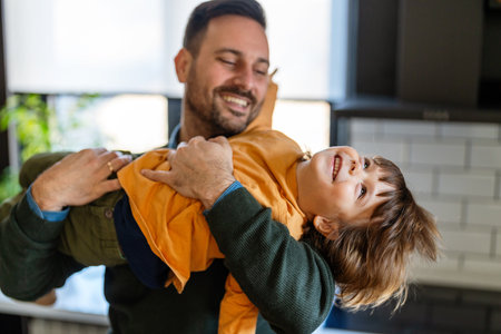 Happy loving daddy and affectionate boy playing, laughing having fun at home. Family leisure conceptの写真素材