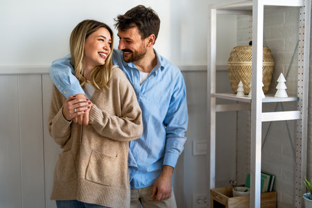 Young diverse couple moving in new home. Couple is having fun in new house at moving dayの写真素材