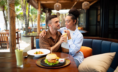 Happy diverse couple enjoying food at the restaurantの写真素材