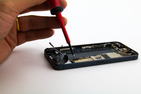One man he was loosen the nut to remove the circuit board from the phone. In The process mobile phone repair.の写真素材