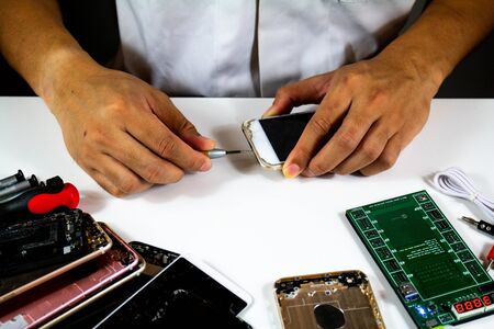 process to change mobile phone batteries Step 2 : The repairman is tightening the nut to see the battery inside the mobile phone.の写真素材