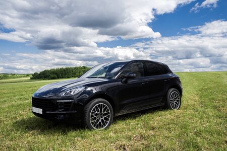 Porsche Macan is a parked on a fresh green spring grass