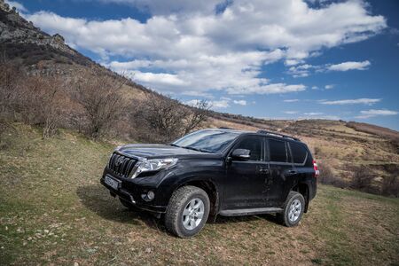 Alushta, Republic of Crimea - March 23, 2019: Black off-road car Toyota Land Cruiser Prado parked in...