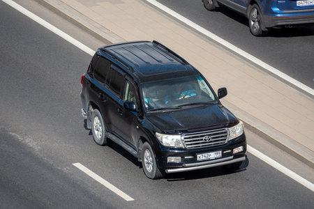 Moscow, Russia - September 27, 2022: A black Japanese car Toyota Land Cruiser 200 is driving down the road on a city streetのeditorial素材