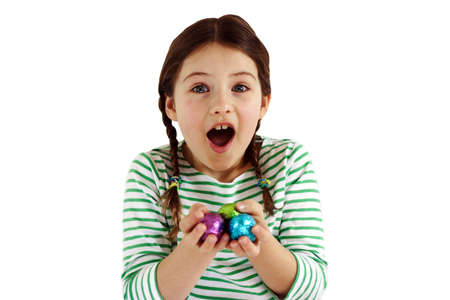 A pretty girl with a surprised look on her face, having received chocolate eggs.の写真素材