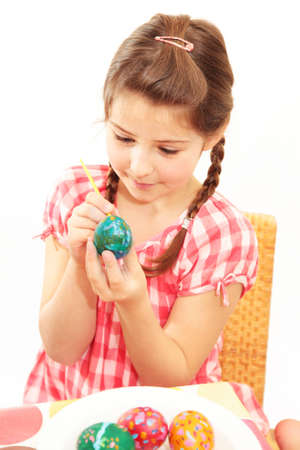 A little girl painting an Easter eggの写真素材