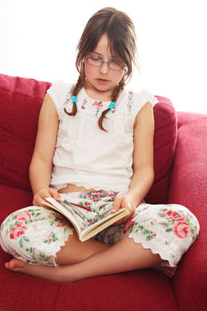 A little girl reading in her pyjamasの写真素材
