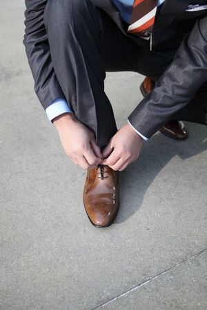 A businessman tying his shoelacesの写真素材