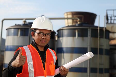 engineer standing in front of a large with blueprint on the hand の写真素材