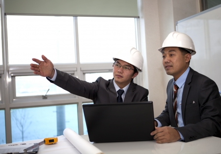 architects sitting at table and discussing a project in the officeの写真素材