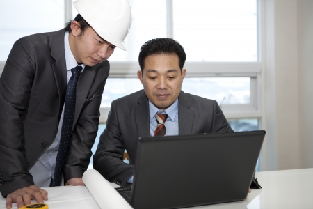architects sitting at table and discussing a project in the officeの写真素材