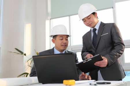 architects sitting at table and discussing a project in the officeの写真素材
