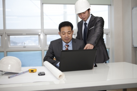 architects sitting at table and discussing project の写真素材