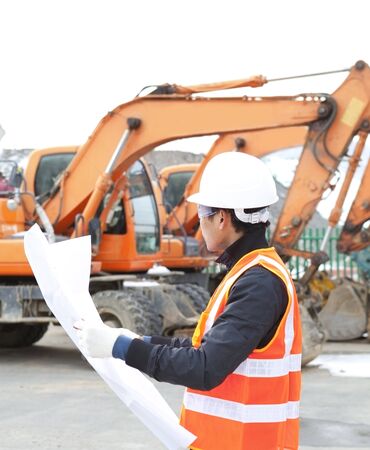 road construction worker and heavy equipment on the backgroundの写真素材