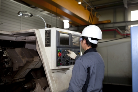 technician worker operating cnc machine centerの写真素材
