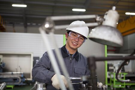 modern industrial machine operator working in factory の写真素材
