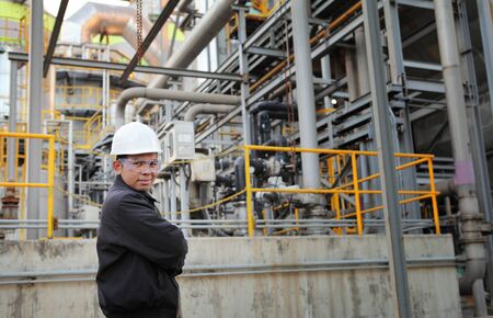 engineer standing beside pipeline inside oil refineryの写真素材