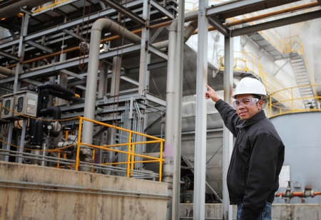 engineer pointing against pipeline inside oil refineryの写真素材