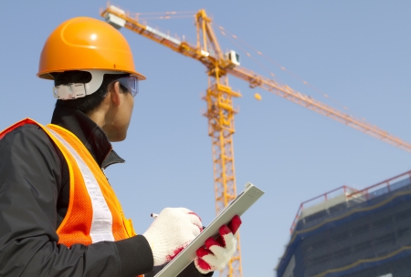 construction worker on location site with crane on the backgroundの写真素材