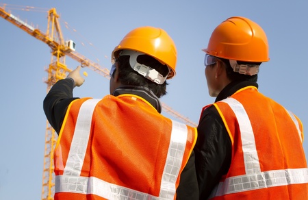 Site manager with safety vest discussion under constructionの写真素材