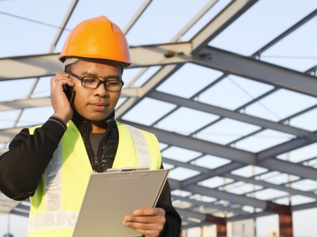 construction engineer communication via mobile phone with safety vest  on location siteの写真素材