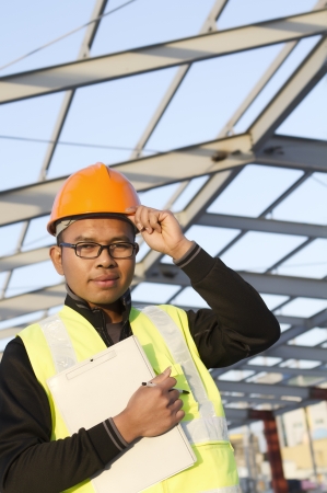 construction engineer holding a notepad with safety vest  looking at the cameraの写真素材