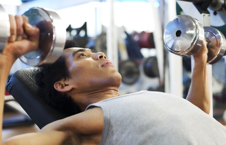 Man gym workout, using dumbbell butterflies to exercise his chestの写真素材
