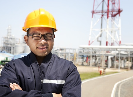 Chemical industrial engineer standing with oil refinery background