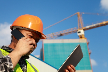 Construction worker activity with mobile phone and digital tabletの写真素材