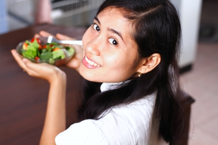 Young woman with fresh salad on the handの写真素材
