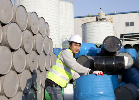 Worker man moving a drum with looking at you cameraの写真素材