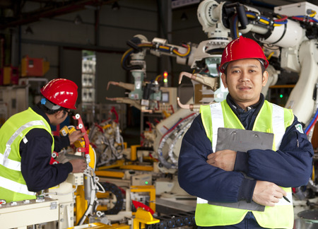 Factory worker standing with partner on the backgroundの写真素材