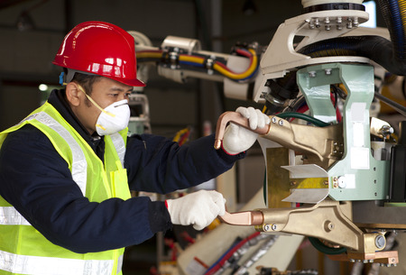 Industrial machine operator checking on robot machine