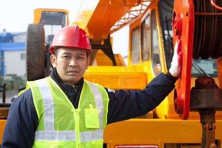 Construction worker standing on crane truckの写真素材
