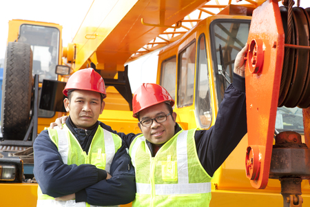 Crane truck  posing next to the huge mobile craneの写真素材