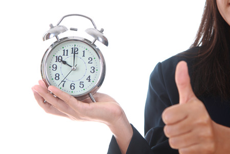 Copy space an alarm clock with woman hand showing succes sign deadline conceptの写真素材