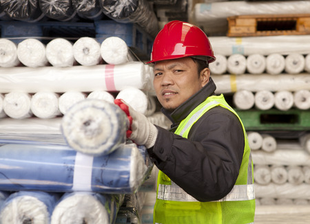 Worker factory textile arranging fabric in werehouse looking at you cameraの写真素材