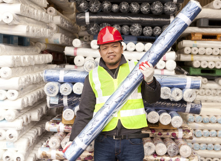 Textile factory worker carrying raw material fabric の写真素材