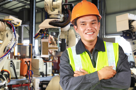 Man factory engineer or worker with robot machine inside modern industrial manufacturing, automobile industryの写真素材