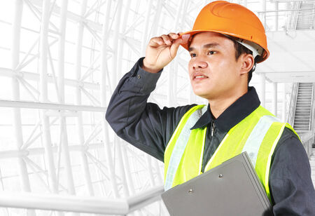 Portrait of an engineer looking at something, standing inside construction siteの写真素材