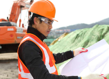 Construction worker checking project on locationの写真素材