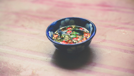 Nuoc Mam - Vietnamese Spicy Fish Sauce in Small bowl on Wooden Backgroundの写真素材