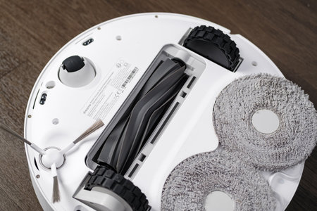 Robot vacuum cleaner on the wooden floor, close-up.のeditorial素材