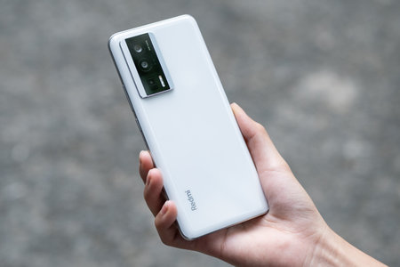 Woman's hand holding a white smart phone with a cassette player.のeditorial素材